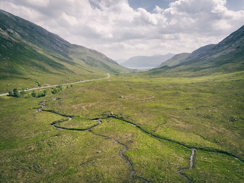 a grassy valley with a road