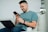 Smiling customer using a smartphone while sitting comfortably at home.
