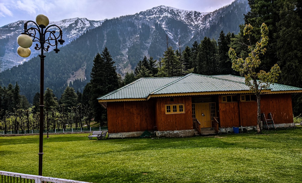 a cabin in a grassy field with a mountain in the background