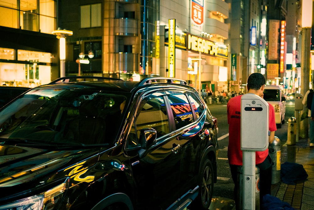 Una persona parada al lado de un coche