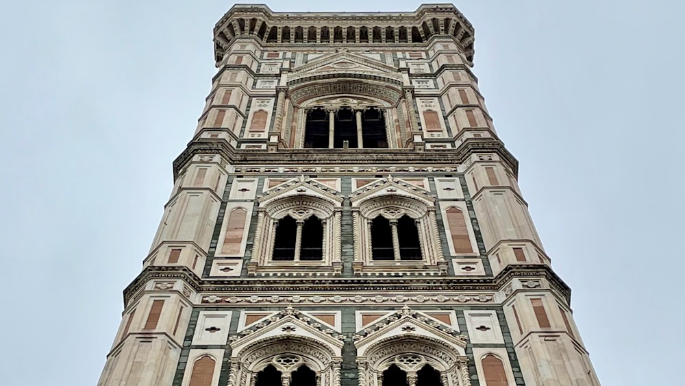 a tall building with many windows with Giotto's Campanile in the background