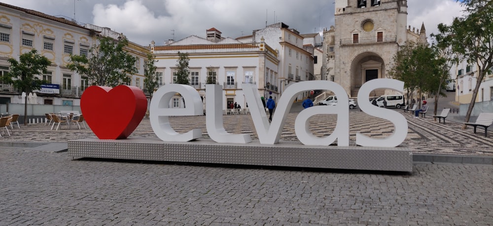 a circular white building with a red ball in front of it