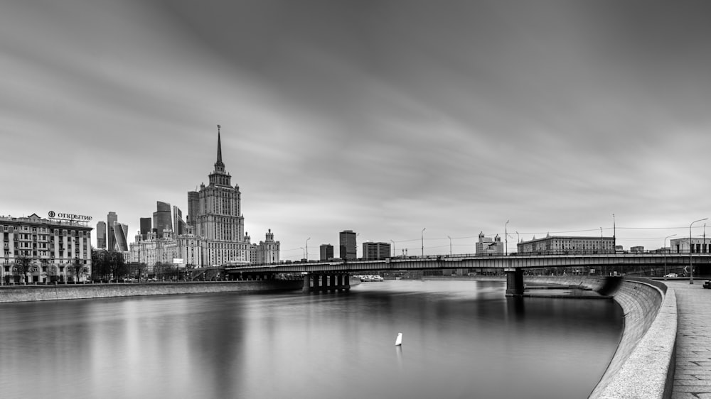 a bridge over a river with a city in the background