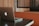 A laptop with a distinctive logo is placed on a dark-colored table. The background features wooden paneling and a cushioned booth, creating a cozy and professional atmosphere.