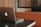 A laptop with a distinctive logo is placed on a dark-colored table. The background features wooden paneling and a cushioned booth, creating a cozy and professional atmosphere.