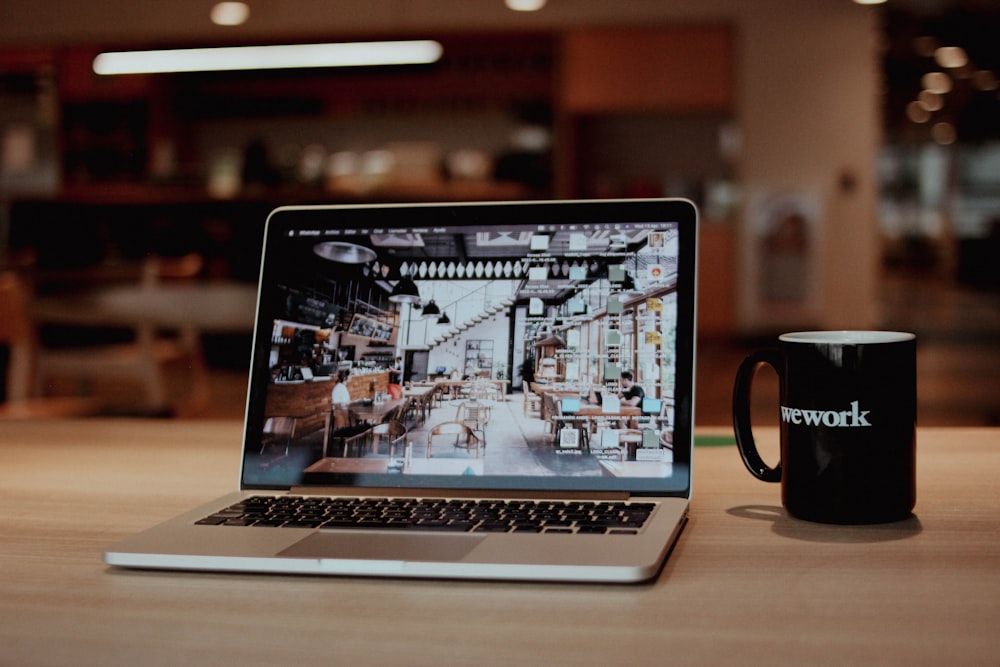 a laptop with a coffee cup