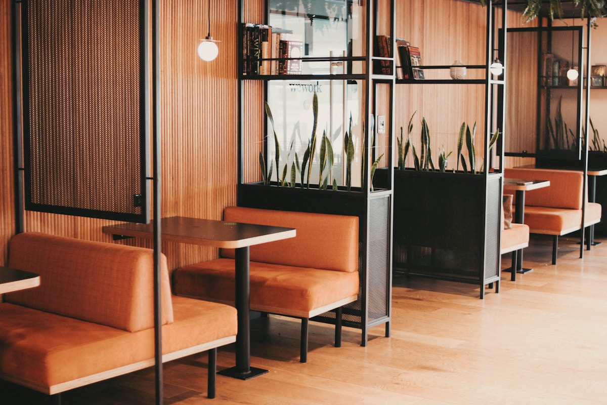 A modern office lounge with a wooden bench and a wall-mounted TV, ideal for hosting team building sign-up events.