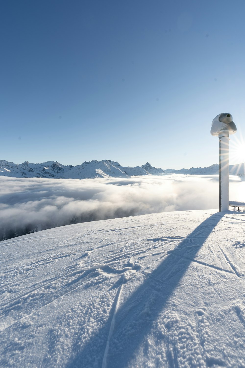 a snowy landscape with a white pole