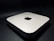 A sleek, minimalist electronic device with rounded edges, featuring a prominent logo on the top surface. The device rests on a dark surface, giving it a modern and sophisticated appearance.