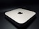 A sleek, minimalist electronic device with rounded edges, featuring a prominent logo on the top surface. The device rests on a dark surface, giving it a modern and sophisticated appearance.