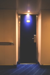 A maintenance worker fixing a door lock in a residential hallway