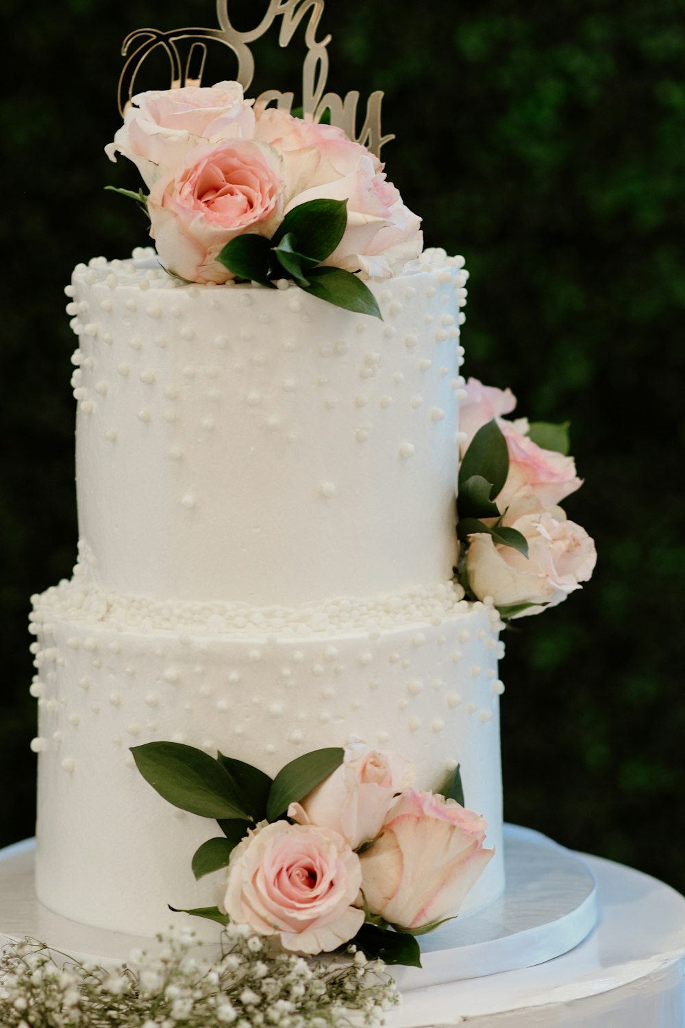 a white cake with pink roses