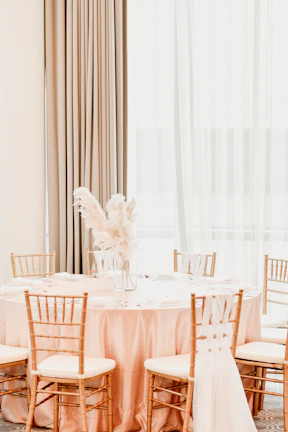Luxurious wedding table setup with blush pink and gold accents under soft lighting.