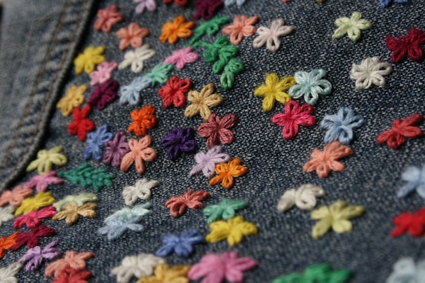 Close-up of a vibrant embroidered patch featuring intricate floral patterns on a denim jacket.