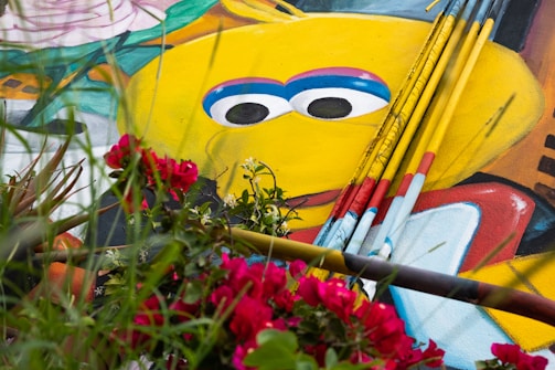 Volunteers painting a bright yellow mural on a community center wall.