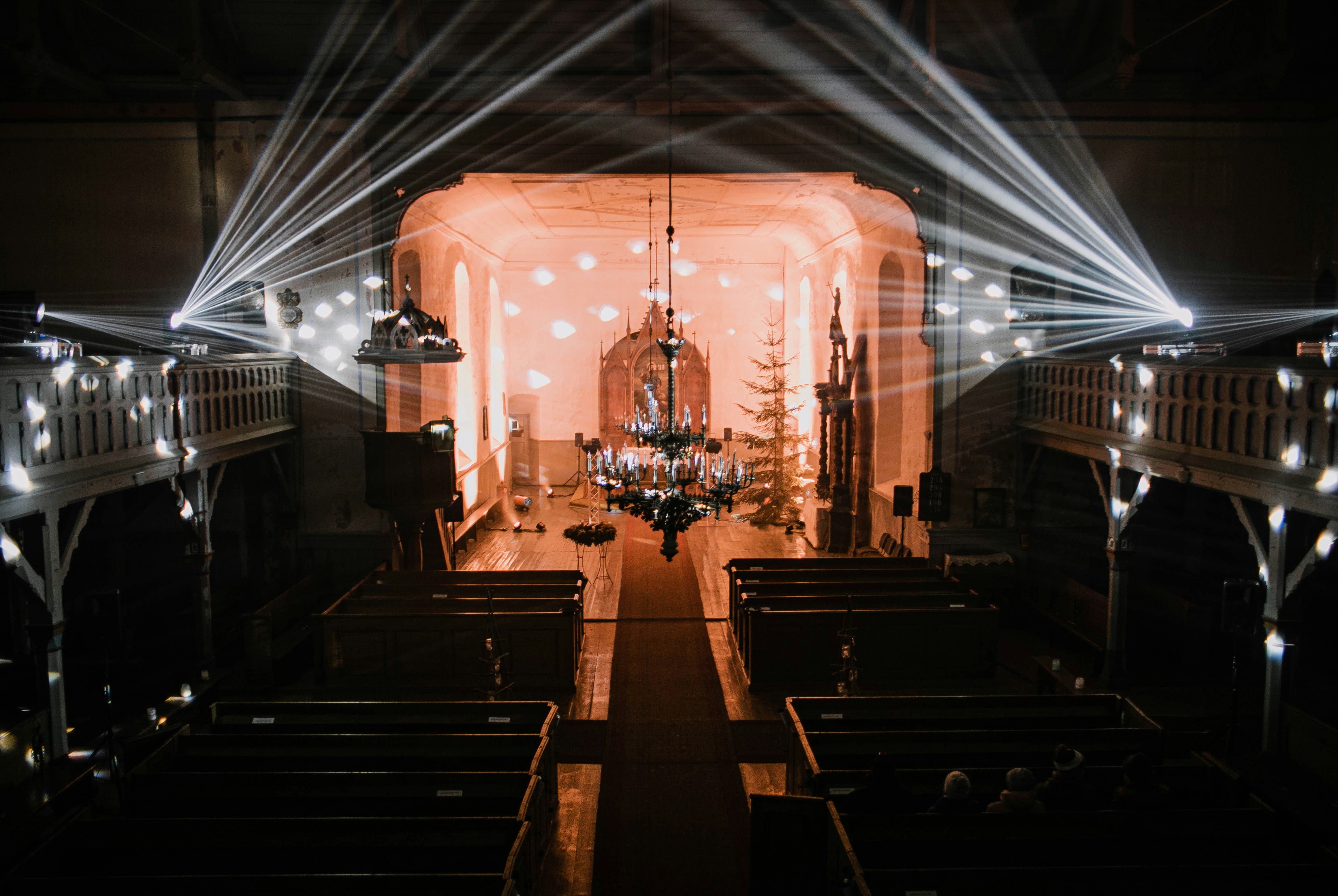 Dramatic church interior with rays of light streaming through stained glass windows
