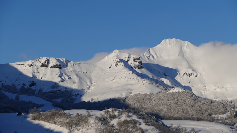 a snowy mountain with clouds