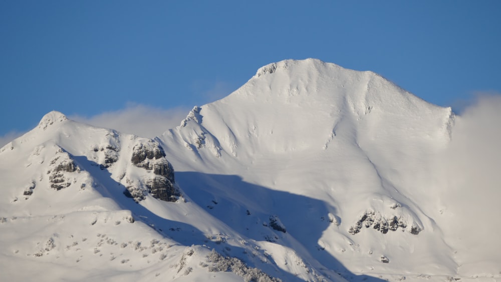 a snowy mountain with clouds