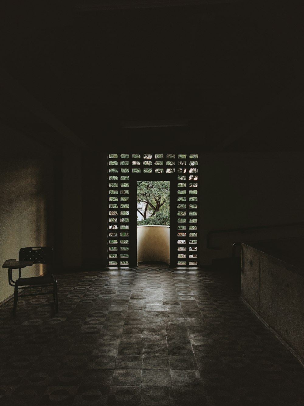 a dark room with a bench and a tree in the middle