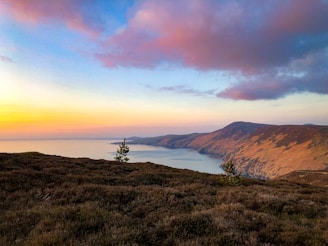 a landscape with hills and a body of water in the distance
