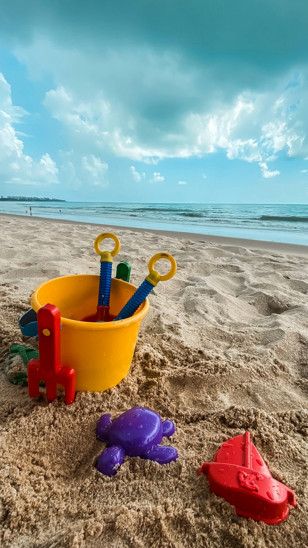 a bucket and toys on a beach