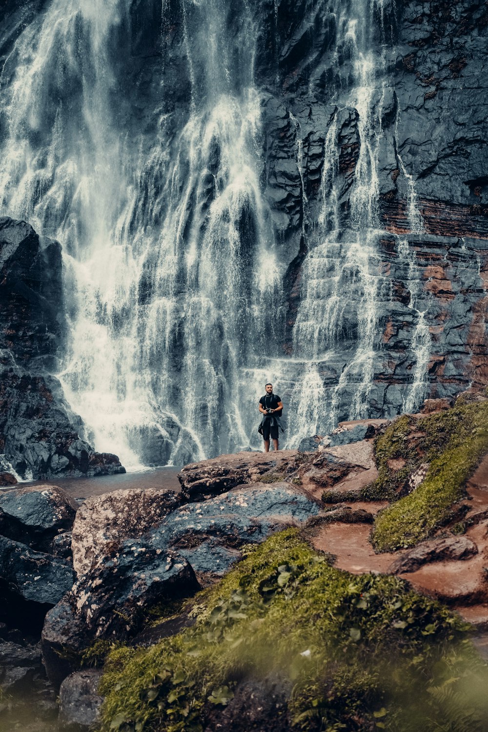 a waterfall with a mountain in the background