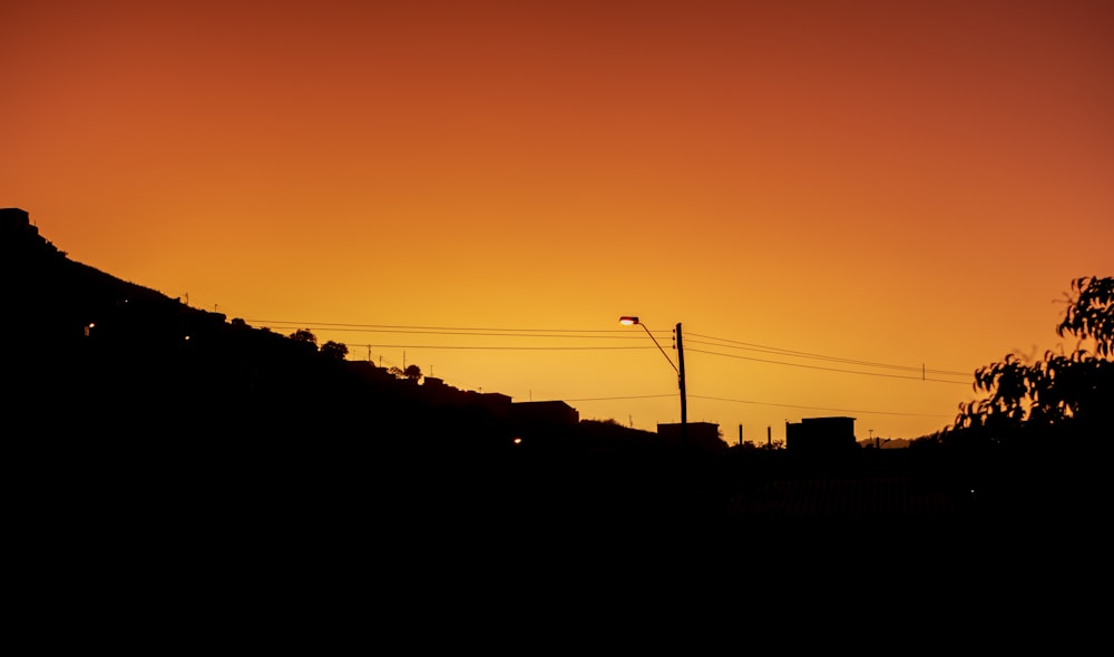 a silhouette of a hill and a sunset