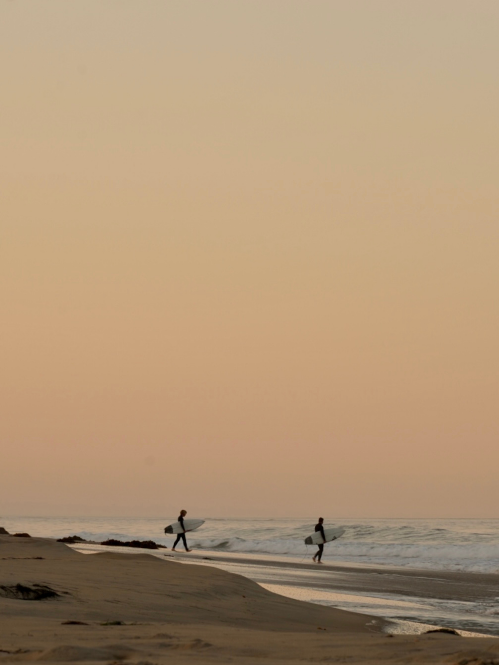 surfers walking on the beach