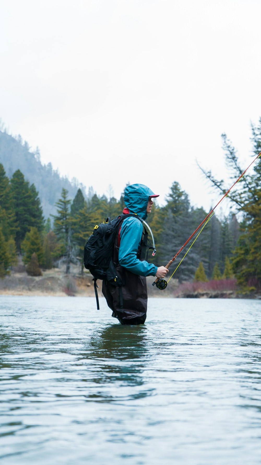 a man with a fishing pole in a lake