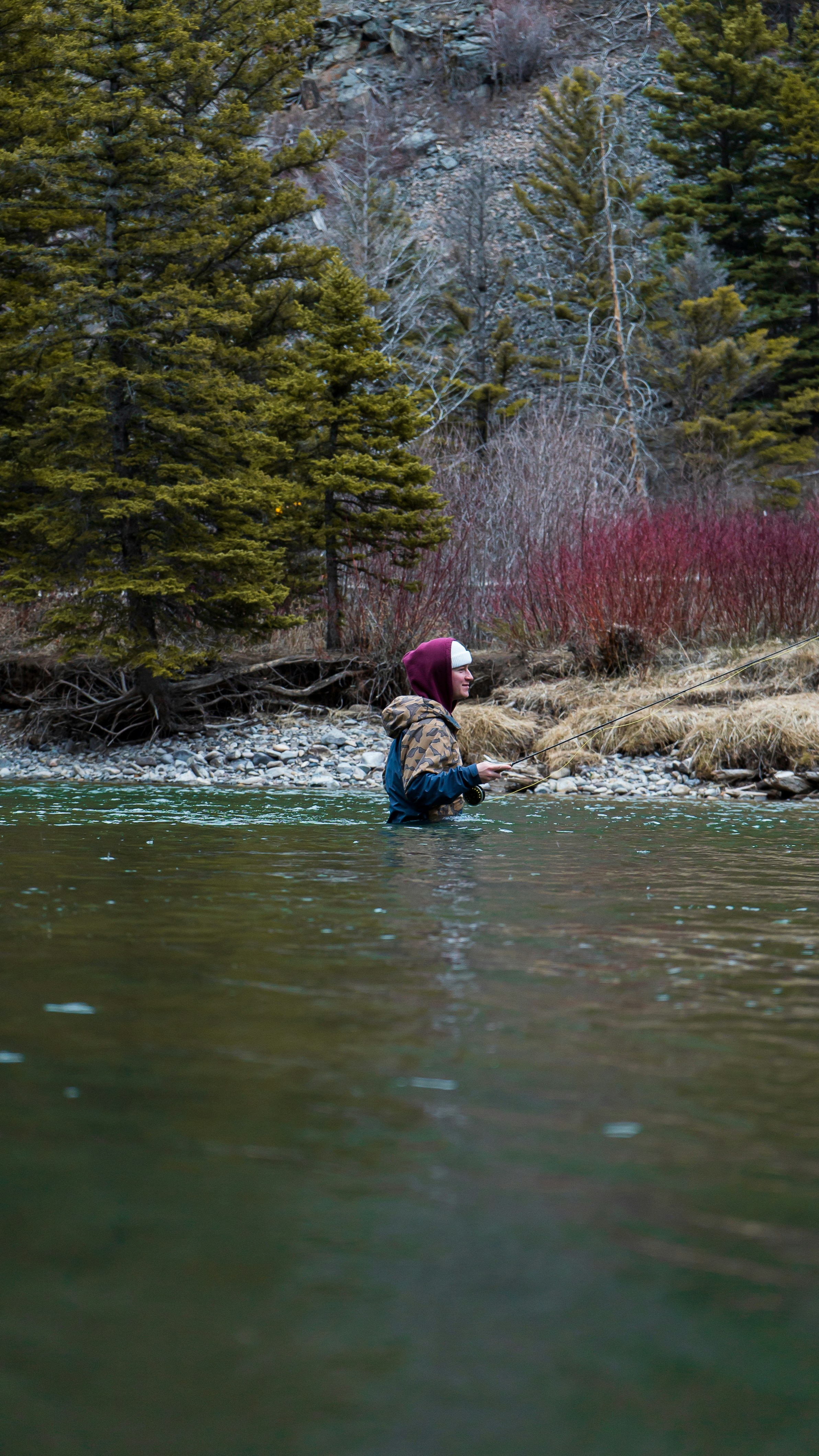 a person in a body of water with trees around it