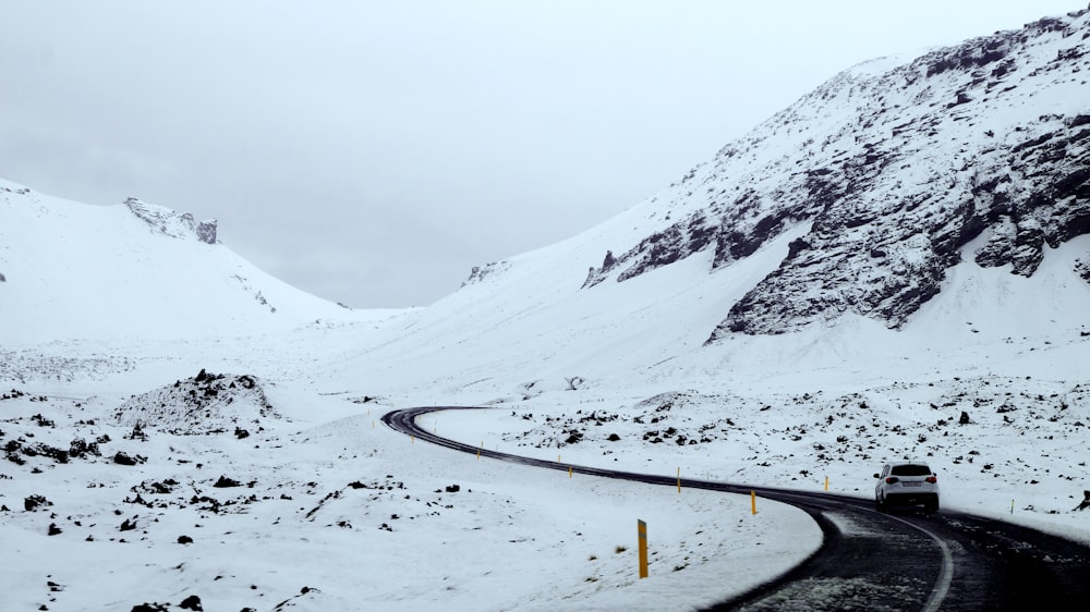 a car driving on a road in the snow