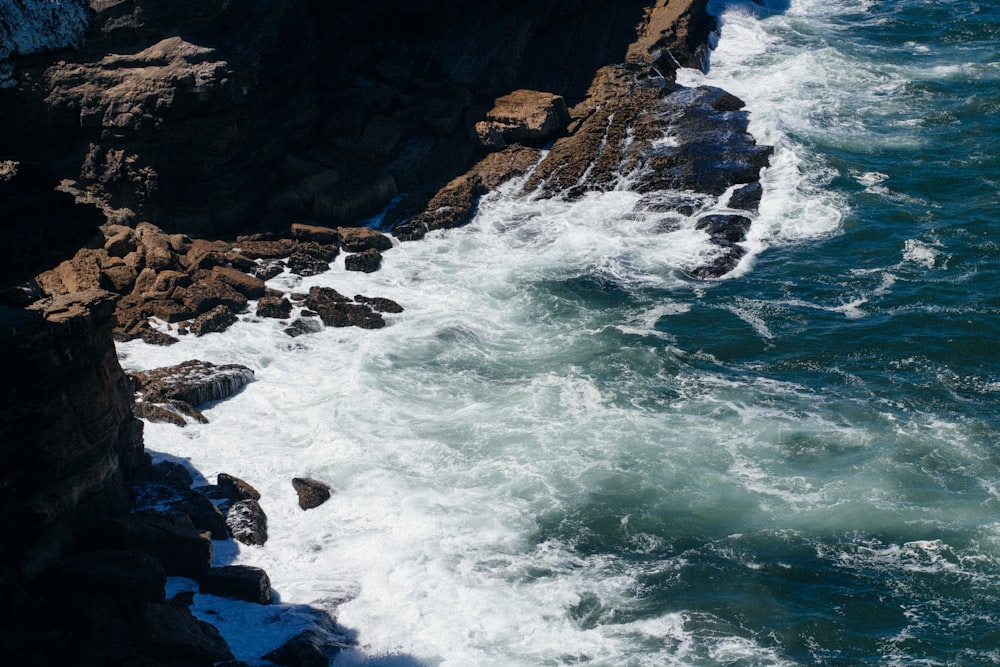 a rocky beach with waves crashing against it