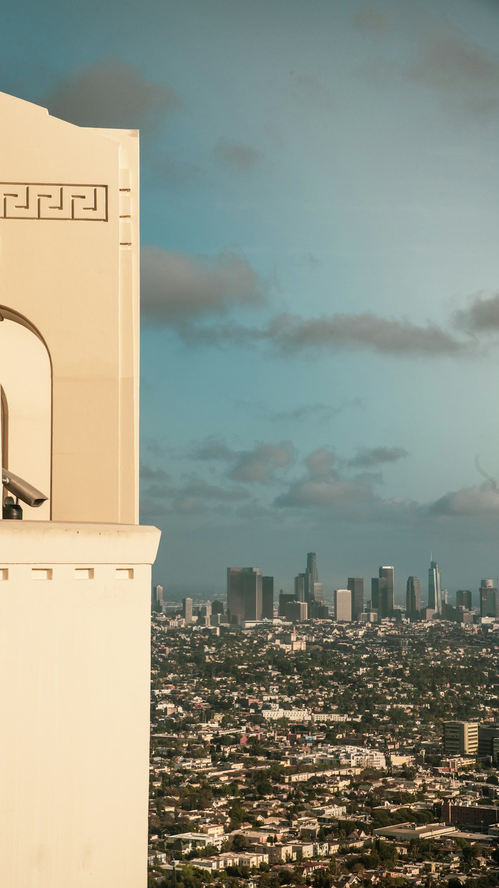 a tall white tower with a city in the background