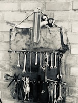 Set of organized mechanic tools hanging on a wall in a garage.