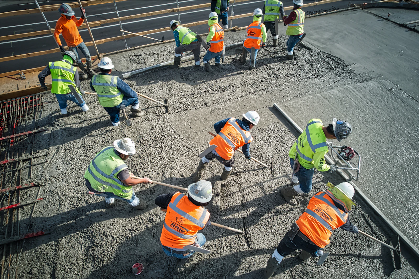 A concrete crew screeding a freshly poured slab