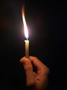 A warm, inviting photo of hands gently holding a glowing candle symbolizing hope and faith.