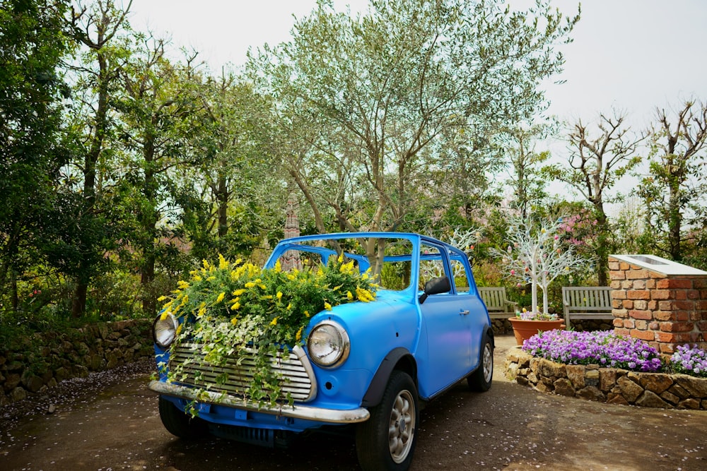a blue truck with flowers in the bed