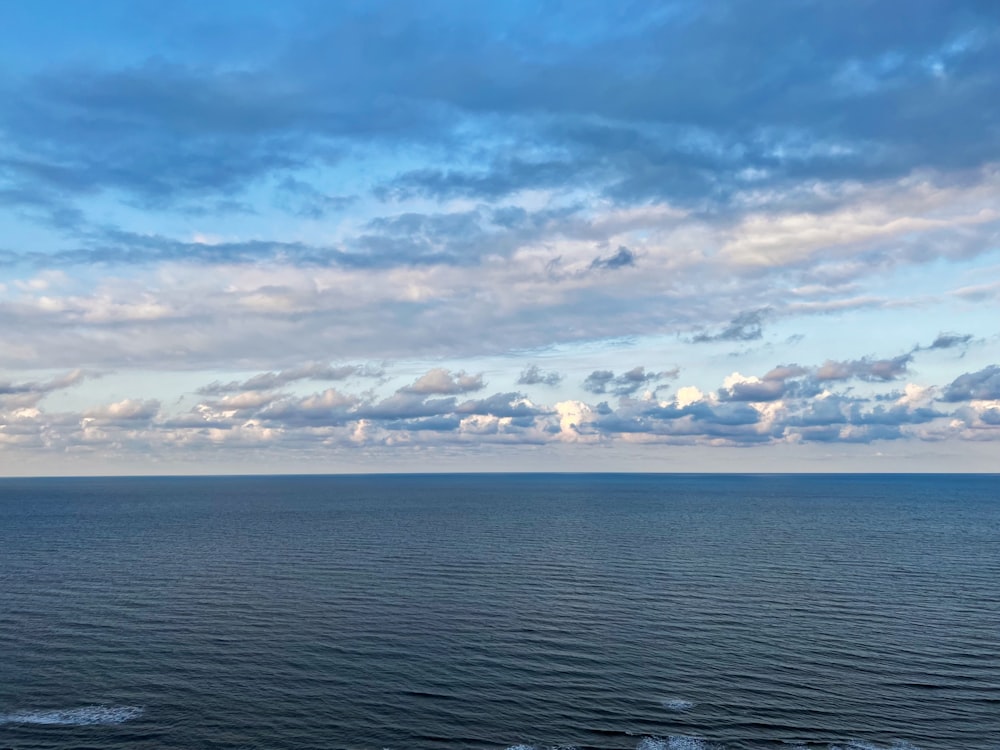 um corpo de água com nuvens acima dele