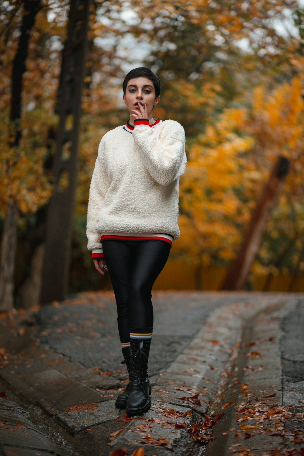 a person standing on a stone path with trees on either side of the