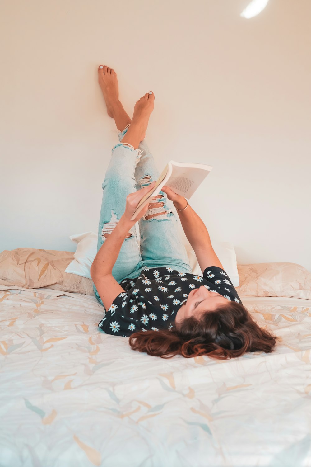 a woman lying on a bed reading a book