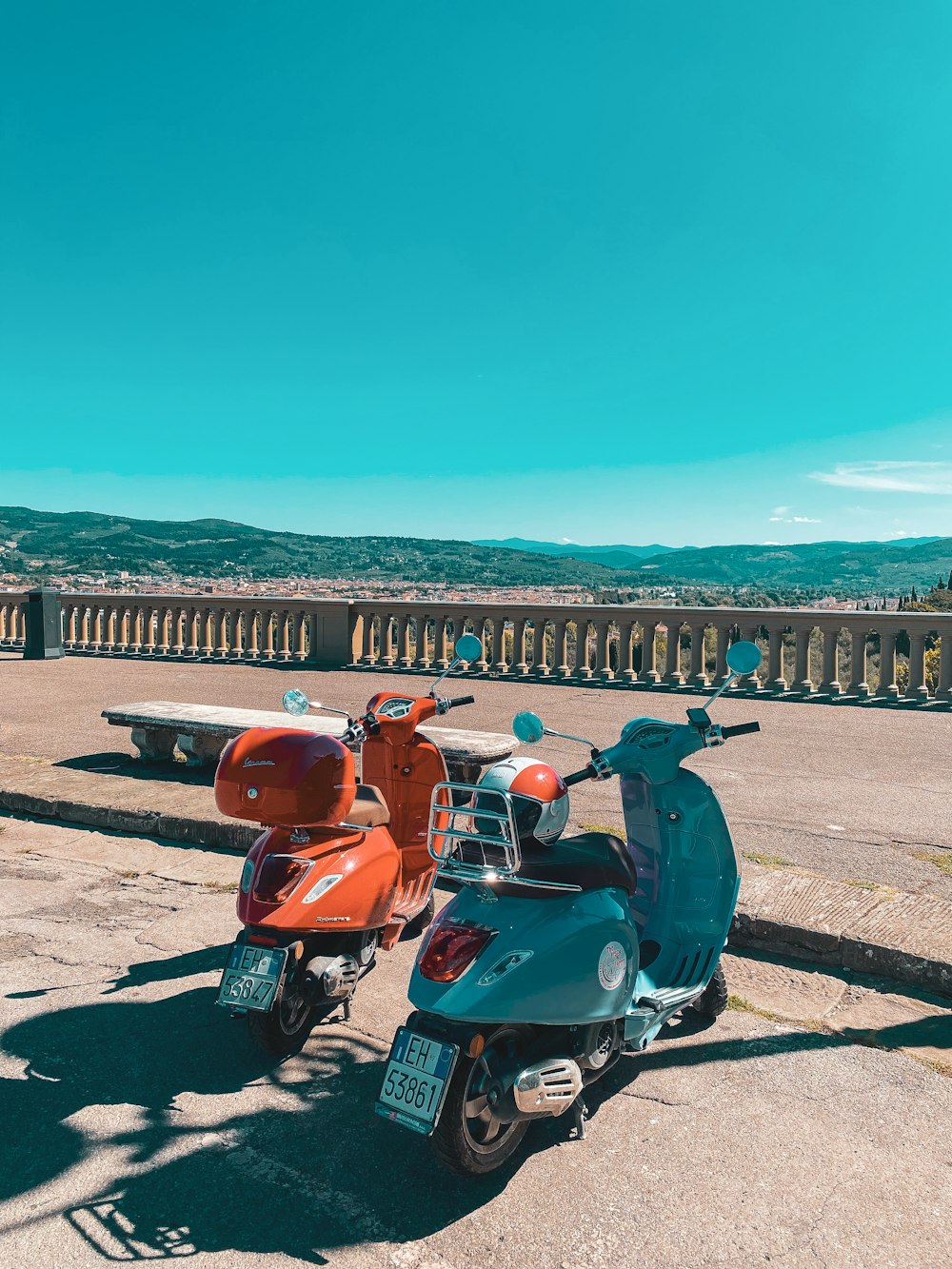 a couple of motorcycles parked on a road by a body of water