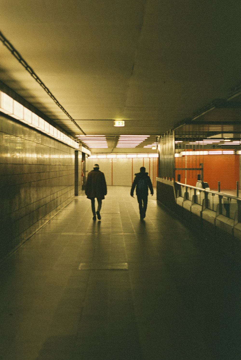 a couple people walking in a tunnel