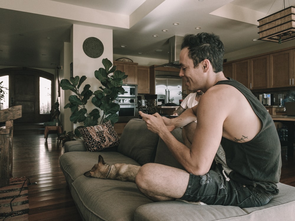 a man sitting on a couch with a cat