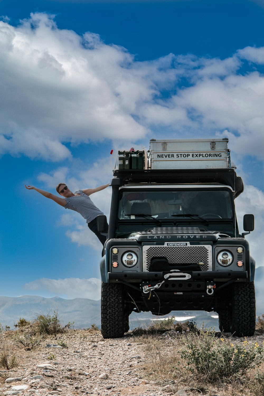 a person standing on the back of a jeep