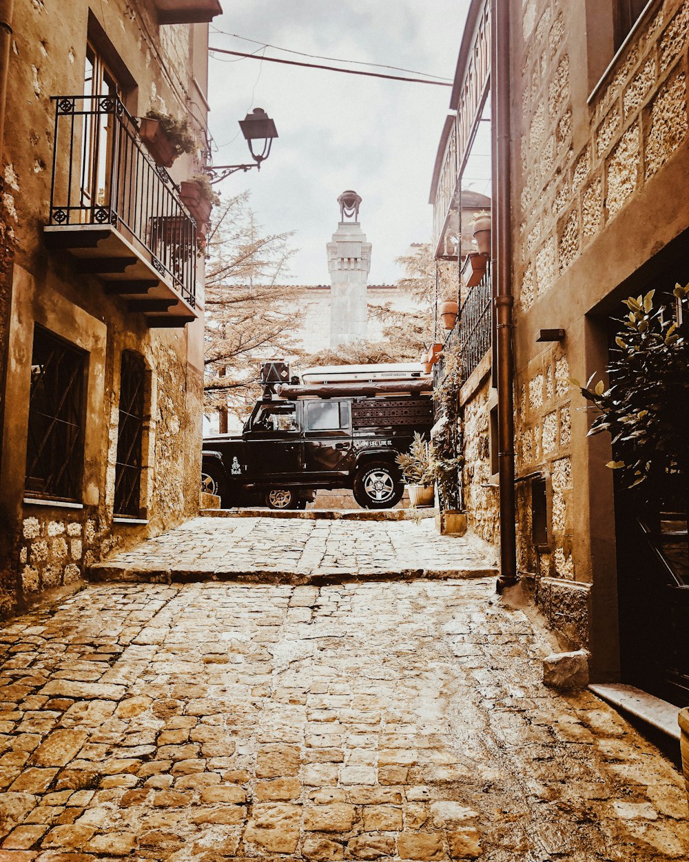 a black truck parked in an alley between buildings