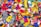 A colorful assortment of knitted socks, featuring a variety of designs and patterns. Each sock is made from vibrant yarns, displaying a mix of stripes, polka dots, and character faces, creating a lively and playful scene.
