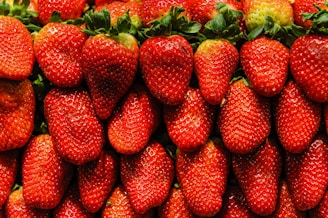 Close-up of dew-kissed strawberries arranged neatly in a wooden crate.