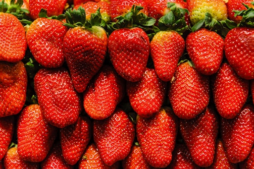 Close-up of dew-kissed strawberries arranged neatly in a wooden crate.