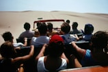 Happy tourists boarding a comfortable transport van with Los Cabos desert landscape behind