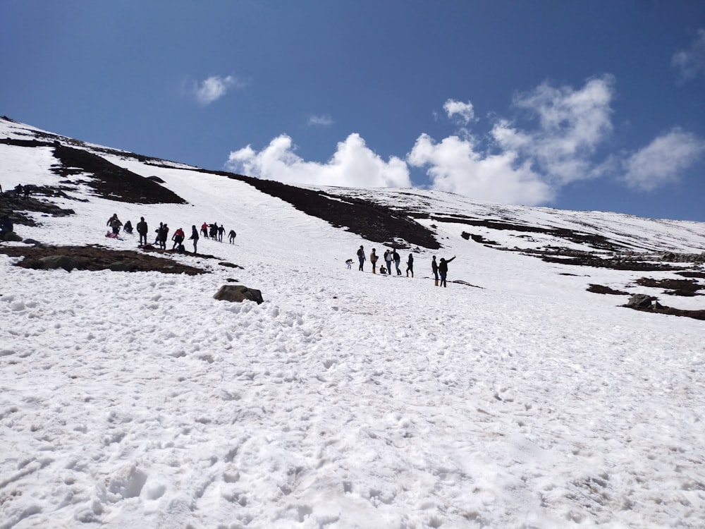 a group of people walking on a snowy mountain